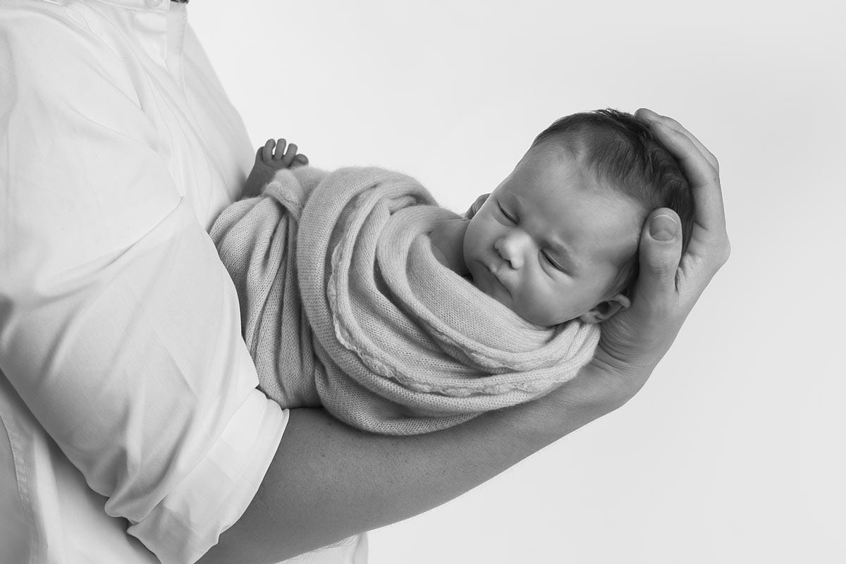 Vater-haelt-Baby-im-Neugeborenen-Shooting-Berlin